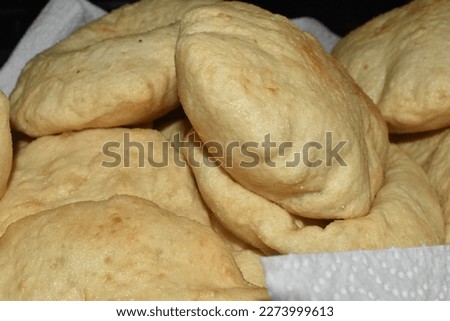 Close up or macro shot of fried bakes. Fried bake or fry bake is a Caribbean dish which is usually served with buljol or saltfish, fried shark, tomatoes and many other sides.