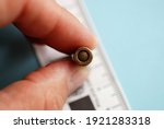 Close macro shot of an old unexploded bullet held by a hand, for police ballistics studies