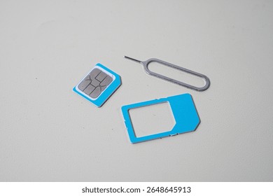 Close up macro of SIM card and SIM tray ejector tool. Perfect for tech blogs, smartphone repair articles, mobile tutorials, or telecommunications-related content