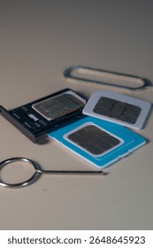 Close up macro of SIM card and SIM tray ejector tool. Perfect for tech blogs, smartphone repair articles, mobile tutorials, or telecommunications-related content