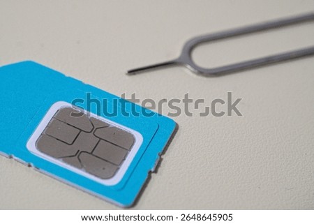Close up macro of SIM card and SIM tray ejector tool. Perfect for tech blogs, smartphone repair articles, mobile tutorials, or telecommunications-related content