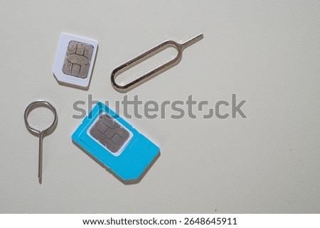 Close up macro of SIM card and SIM tray ejector tool. Perfect for tech blogs, smartphone repair articles, mobile tutorials, or telecommunications-related content