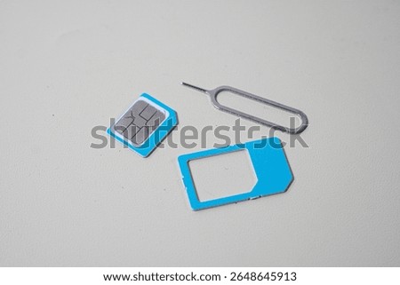 Close up macro of SIM card and SIM tray ejector tool. Perfect for tech blogs, smartphone repair articles, mobile tutorials, or telecommunications-related content
