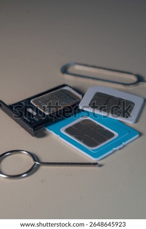 Close up macro of SIM card and SIM tray ejector tool. Perfect for tech blogs, smartphone repair articles, mobile tutorials, or telecommunications-related content
