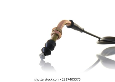 Close up macro view of motorcycle control cable end featuring yellow zinc plated threaded adjuster, hex locknuts, curved metal elbow tube, black rubber boot dust shield, and steel wire nipple, professional studio product photography shot on reflective white background.
