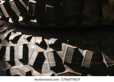 Close macro view showing dramatic rugged black rubber tread texture featuring geometric abstract pattern highlighting industrial strength and tough surface detail