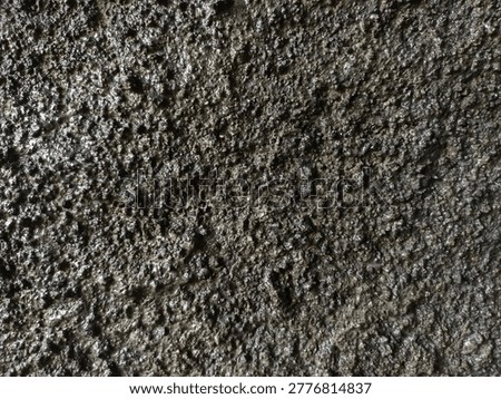 Close up macro of wet dark rough concrete texture with water droplets. Extreme grunge industrial wall surface background for 3D material, horror poster, video overlay, or urban design. High detail wet cement.