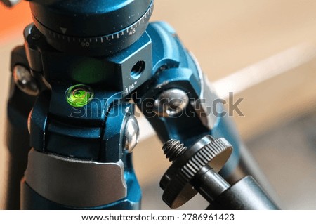 Close up of a magic arm mount with 1 4 inch threaded screw beside a tripod mounting hole for photography equipment