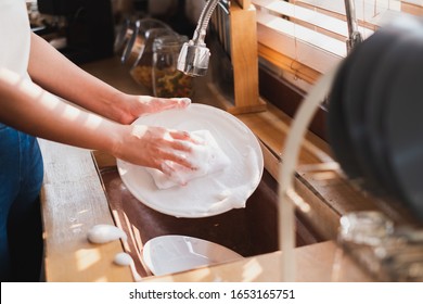 Close up maid housewife washing cleaning dishes in kitchen