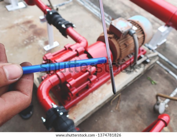 close up of maintenance man check oil of\
moter fire pump machine in the factory    \
