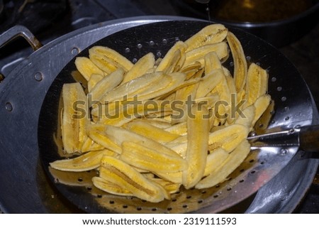 Close up of making a light snack of yellow banana chips