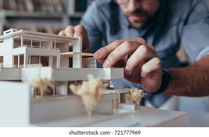 Close up of male architect hands making model house. Man architect working in the office. - Shutterstock ID 721777969