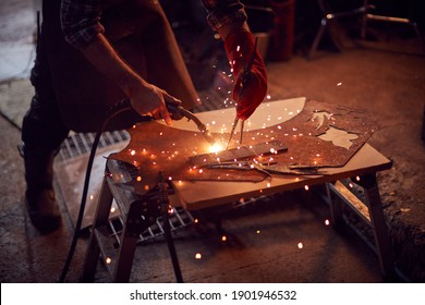 Close Up Of Male Blacksmith Arc Welding Metalwork In Forge - Powered by Shutterstock