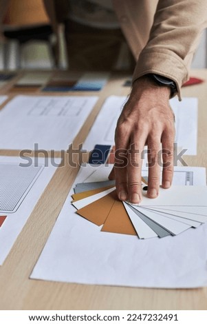 Close up of male designer choosing color palette while working on creative project