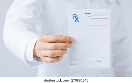 Close Up Of Male Doctor Holding Rx Paper In Hand