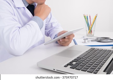 Close Up Of A Male Doctor In Scrubs Using Digital Tablet, Male Handsome Doctor Thinking