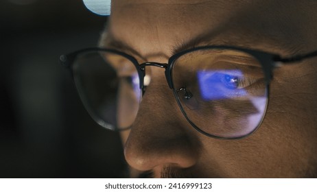 Close up male eyes in glasses eye strain problem medicine night dark man businessman developer computer programmer business man looking at screen blue laptop display monitor reflection in eyeglasses - Powered by Shutterstock