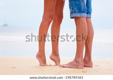 Close up male and female feet on the sand