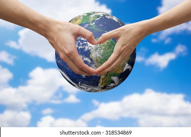 Close Up Male And Female Hands Making Heart Shape Over The Global On Blur Sky For Safe The World Concept:Elements Of This Image Furnished By NASA