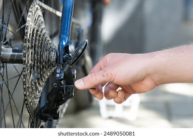 close up of a male hand adjusting bicycle rear derailleur. Bike mechanic adjust Rear Derailleur and repair bicycle in workshop. ,bicycle maintenance and repair concept - Powered by Shutterstock