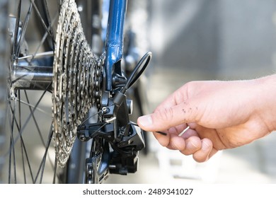 close up of a male hand adjusting bicycle rear derailleur. Bike mechanic adjust Rear Derailleur and repair bicycle in workshop. ,bicycle maintenance and repair concept - Powered by Shutterstock