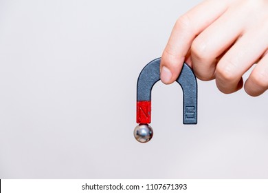 Close up of male hand holding horseshoe magnet