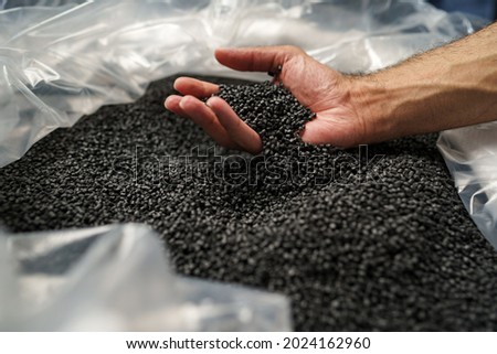 Close up of male hand holding plastic polymer granules