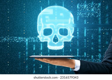 Close up of male hand holding tablet with glowing digital blue glitch skull hologram on dark background. Virus, crime and hacking concept