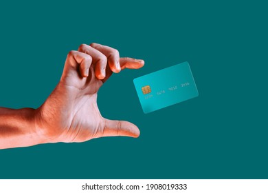 Close up male hand and levitating template mockup bank credit card with online service isolated on green background