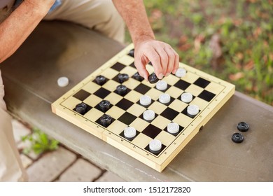 Close up of male hand moving checker on checkerboard stock photo - Shutterstock ID 1512172820