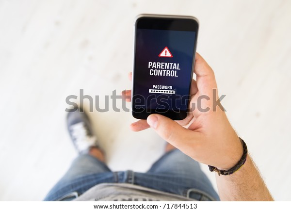 close\
up of male hand with parental control smart\
phone