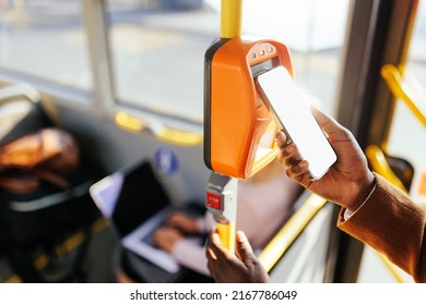 A close up of a male hand paying his bus fare with a smartphone