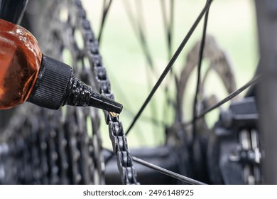 close up of male hand putting oil on bike chain, lubricating bike chain, greasing a bicycle chain, bicycle maintenance - Powered by Shutterstock