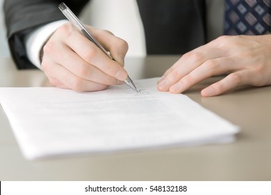 Close up of male hand putting signature in the contract, entering into the new contract, written statement declaring the price. Business partnership concept