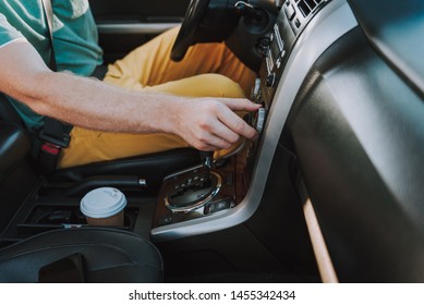 Close Up Of Male Hand Turning The Button On Car Radio And Searching Favorite Song