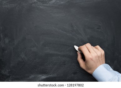 Close up of male hand writing on a blackboard with copy space for some text