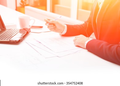Close up male hands businessman. Closeup table and document. Businessman working at sunset with documents. Business man using laptop on table in with a cup of coffee. Background image.
