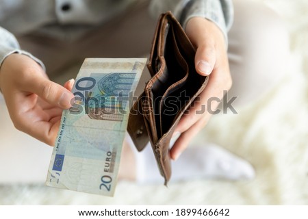 Close up male hands with empty wallet taking out last cash money euros. Man holding currency remains and purse. Bankruptcy economic financial, income decline, poverty, unemployment concept, top view.