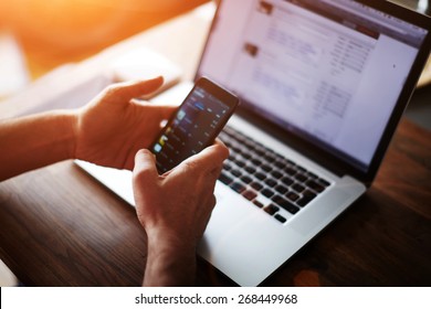 Close Up Male Hands Holding Big Smart Phone While Connecting To Wireless, Businessman Using Technology Sitting At Modern Loft Wooden Desk, People And Modern Devices Everywhere, Flare Sun Light