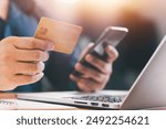 Close up Male hands holding credit card and smartphone, man paying online, credit card shopping, using banking service, entering information, shopping, ordering in internet store, doing secure payment