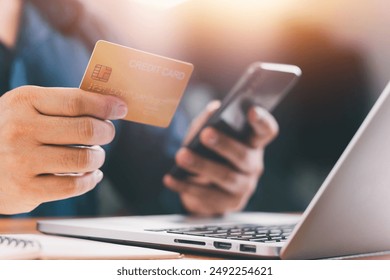 Close up Male hands holding credit card and smartphone, man paying online, credit card shopping, using banking service, entering information, shopping, ordering in internet store, doing secure payment