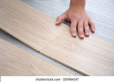 close up of male hands intalling wood flooring
