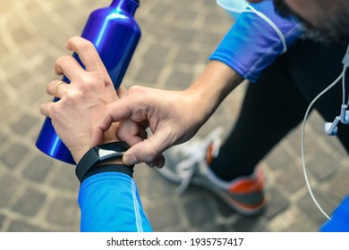 Close Up Of Male Hands Using Fitness App On Smart Watch. Man Resting After Jogging Reading Run Results. Running Man With Smartwatch Recording Data About Sport Activity Boy Checking Wearable Technology