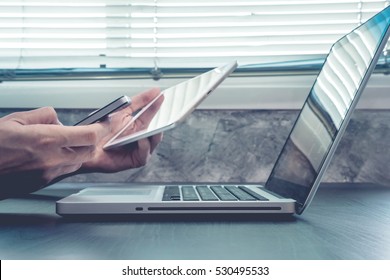 Close Up Of Male Hands Using Laptop, Tablet And Smart Phone On The Desk