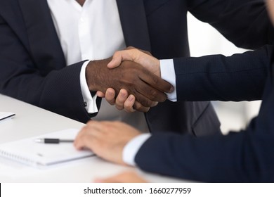 Close Up Of Male Handshake After Effective Negotiation. African American And White Men Shaking Hands Making Agreement, Success Business Conversation With Partner, Man Racial Equality In Relationship.