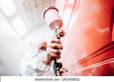 Close Up Of Male Holding Spray Gun And Painting A Car