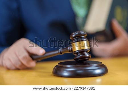 close up male Judge hitting Gavel off a block in courtroom, law and Justice concept