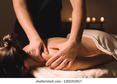 Close Up Male Manual Worker Doing Spa Massage To A Young Girl In A Dark Room