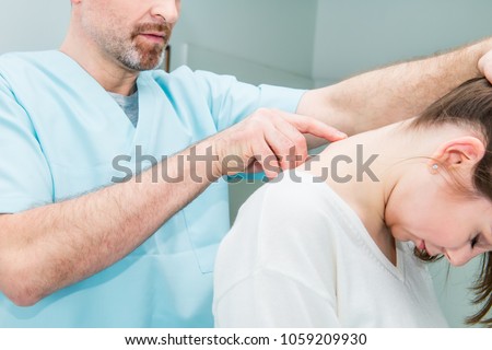 Close up Male neurologist doctor examines cervical vertebrae of female patient spinal column in medical clinic. Neurological physical examination. Osteopathy, chiropractic, physiotherapy
