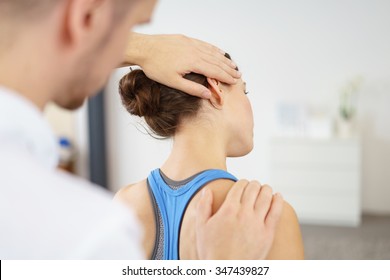 Close up Male Physical Therapist Stretching the Injured Neck of a Female Patient Slowly. - Powered by Shutterstock